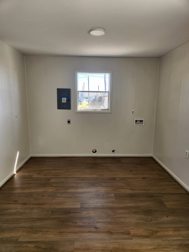 spare room with dark hardwood / wood-style flooring and electric panel