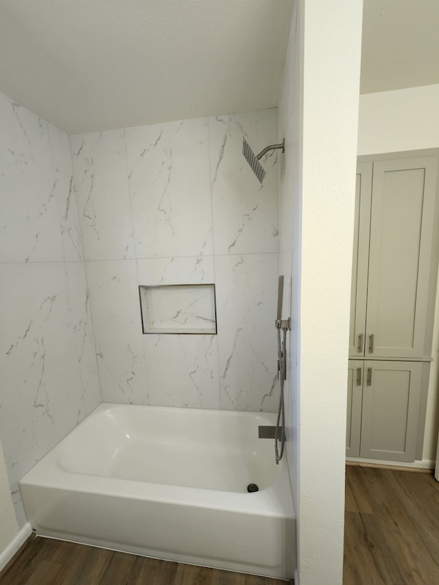 bathroom featuring hardwood / wood-style flooring and tiled shower / bath combo