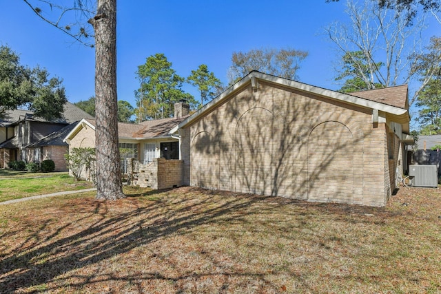 view of side of property with a yard and central air condition unit