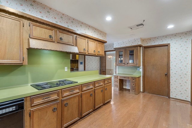 kitchen featuring decorative light fixtures, light hardwood / wood-style flooring, and black appliances