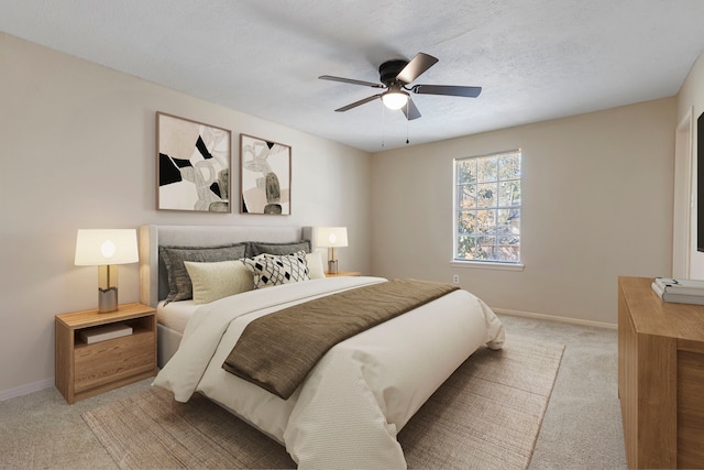 bedroom with a textured ceiling, light colored carpet, and ceiling fan