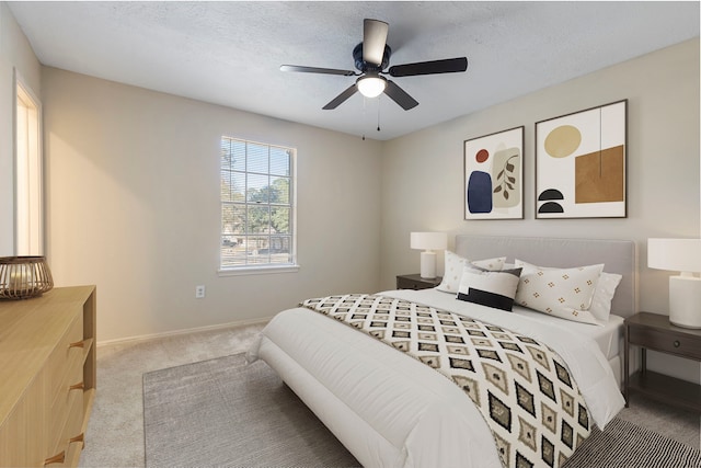 carpeted bedroom featuring ceiling fan and a textured ceiling