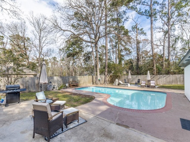 view of swimming pool featuring a patio, grilling area, a fenced backyard, and a fenced in pool