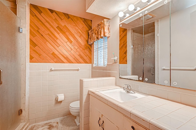 bathroom featuring wooden walls, tile walls, vanity, walk in shower, and toilet