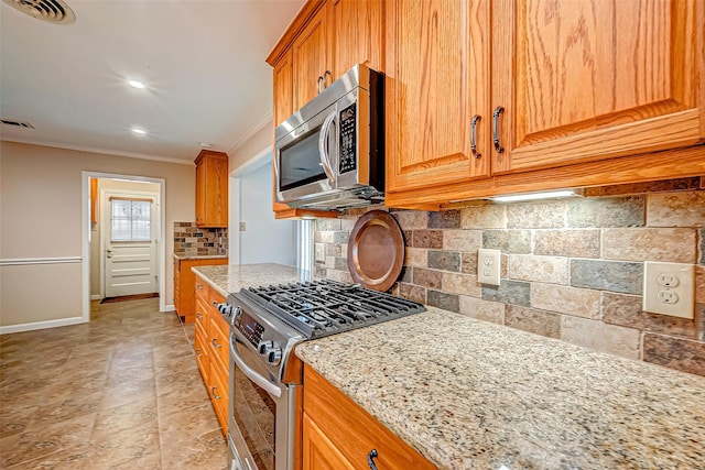 kitchen with light stone counters, stainless steel appliances, crown molding, and decorative backsplash