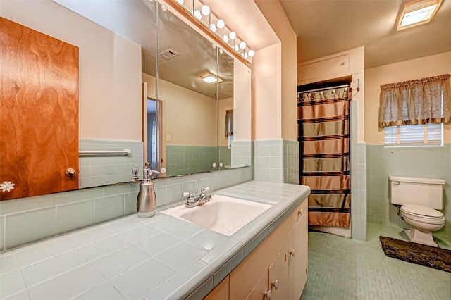 bathroom featuring tile walls, vanity, tile patterned floors, and toilet