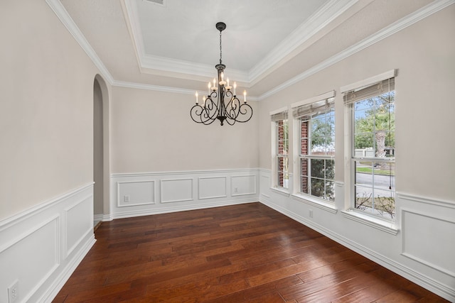 spare room with a raised ceiling, crown molding, an inviting chandelier, and dark hardwood / wood-style flooring