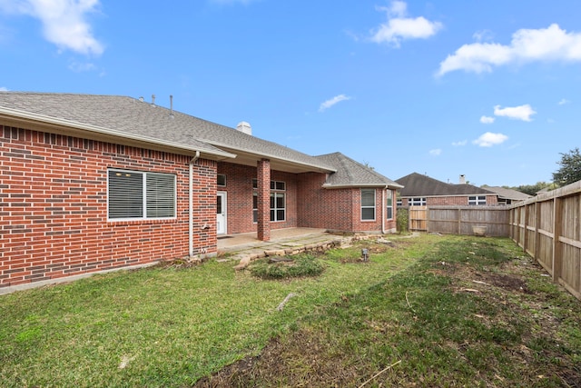 back of house featuring a yard and a patio area