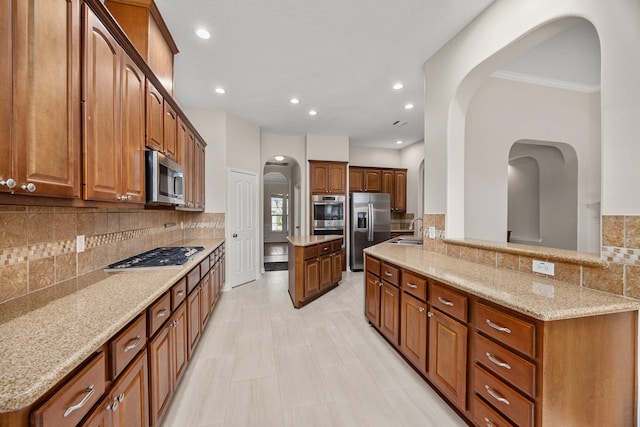 kitchen featuring light stone counters, sink, tasteful backsplash, and appliances with stainless steel finishes