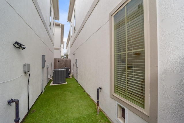 view of side of property featuring central AC and a yard