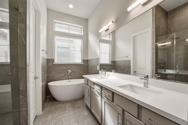 bathroom featuring vanity, separate shower and tub, and tile walls