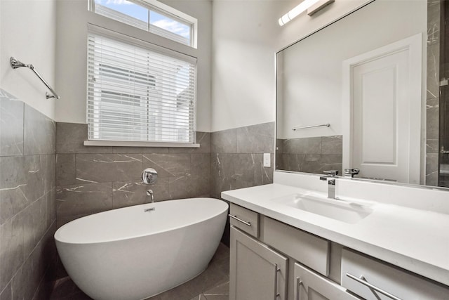 bathroom featuring vanity, a bathtub, and tile walls