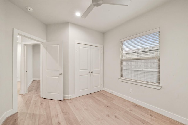 unfurnished bedroom featuring ceiling fan, light wood-type flooring, and a closet