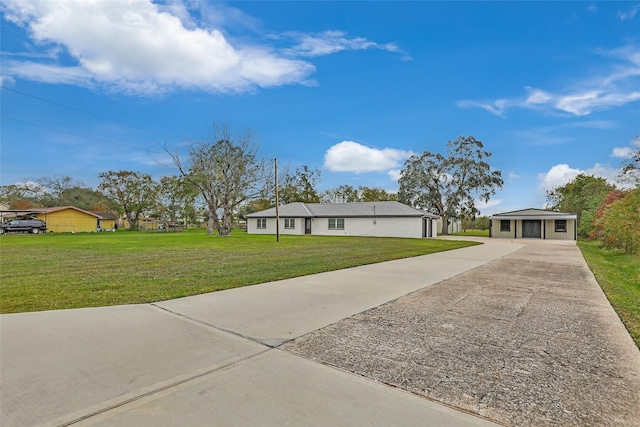 view of front of property with a garage, an outdoor structure, and a front yard