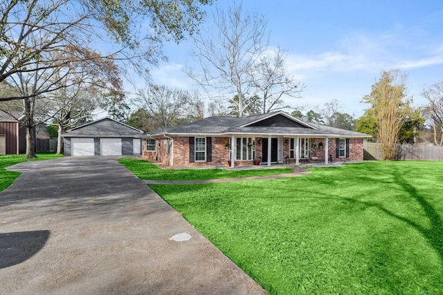 single story home with an outbuilding, a garage, a front lawn, and covered porch