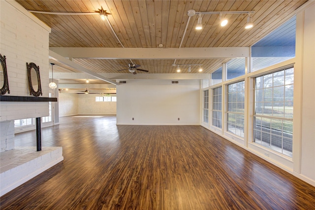 unfurnished living room featuring dark wood-type flooring, wood ceiling, beamed ceiling, ceiling fan, and brick wall