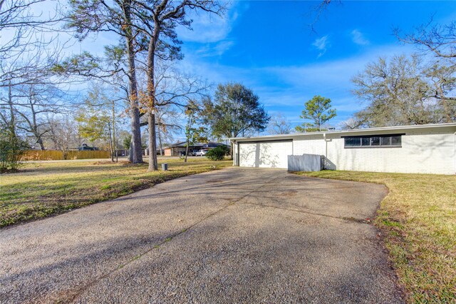 exterior space featuring a garage and a front lawn