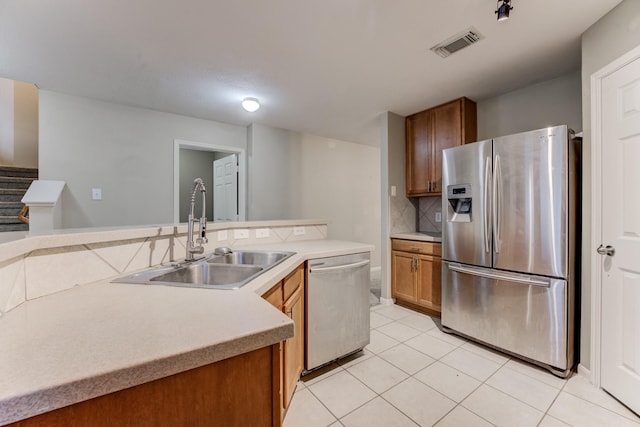 kitchen with sink, decorative backsplash, stainless steel appliances, and light tile patterned flooring