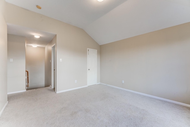 unfurnished bedroom with light colored carpet and lofted ceiling