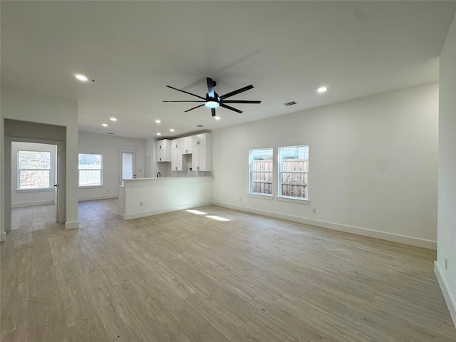 unfurnished living room with ceiling fan and light hardwood / wood-style flooring