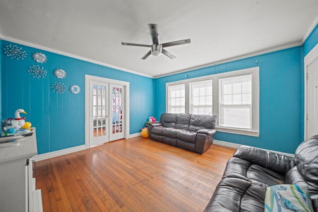 living room featuring wood-type flooring, ornamental molding, and ceiling fan