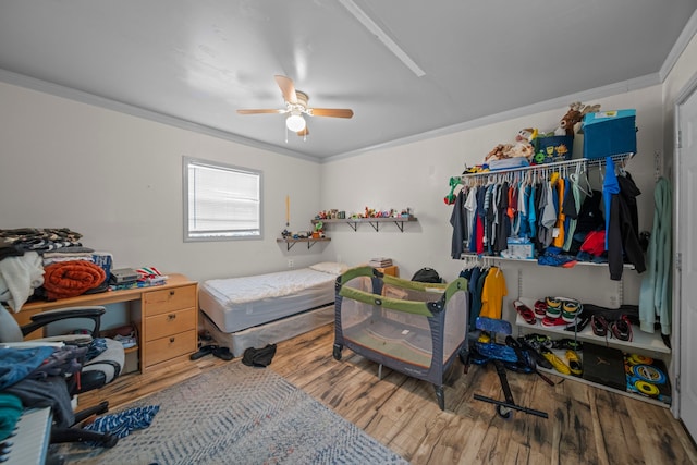 bedroom with hardwood / wood-style floors, crown molding, and ceiling fan