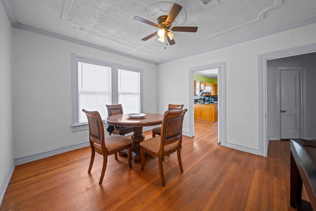 dining room featuring ceiling fan, hardwood / wood-style floors, and a textured ceiling