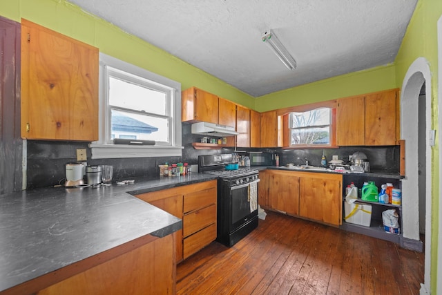 kitchen with sink, dark hardwood / wood-style flooring, decorative backsplash, black appliances, and a textured ceiling