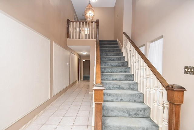 staircase featuring a high ceiling and tile patterned floors