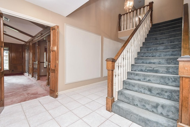 staircase with vaulted ceiling with beams and tile patterned floors