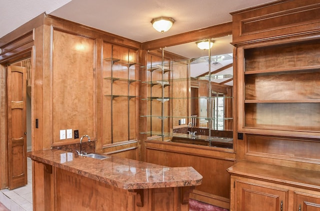 bar featuring stone countertops and sink