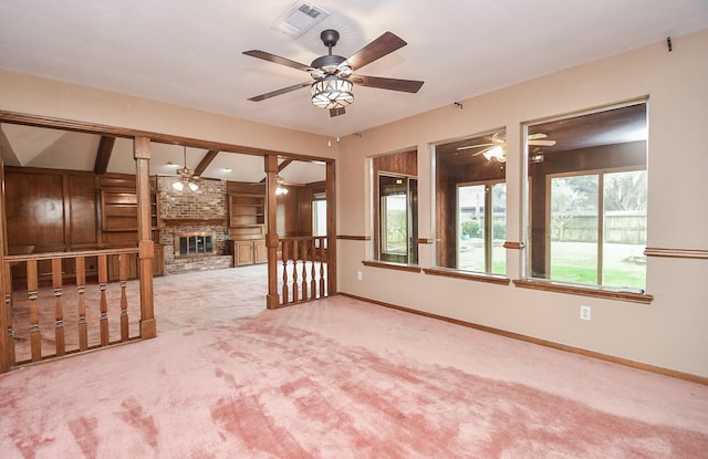 empty room with light carpet, a brick fireplace, and ceiling fan