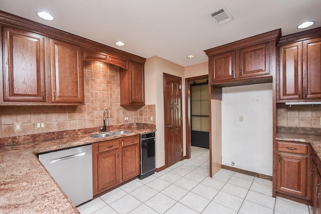 kitchen with light tile patterned flooring, stone countertops, dishwasher, sink, and decorative backsplash