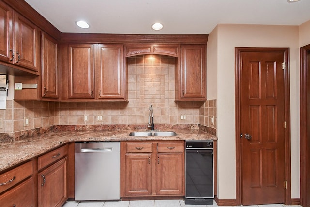 kitchen with dishwasher, sink, backsplash, light tile patterned floors, and light stone countertops