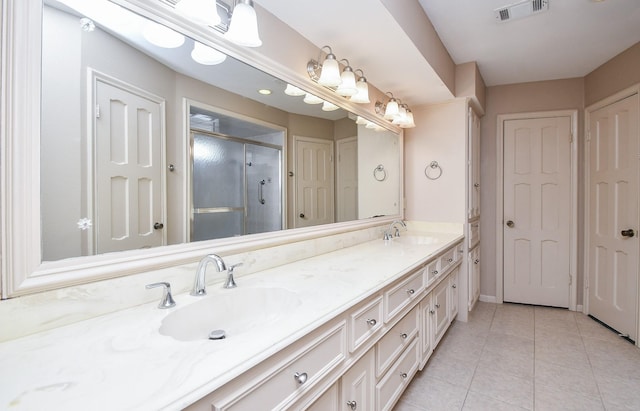 bathroom featuring an enclosed shower, vanity, and tile patterned floors