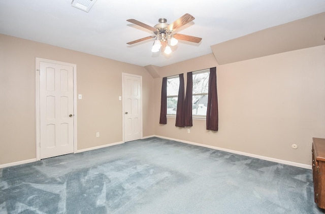 spare room featuring dark colored carpet and ceiling fan