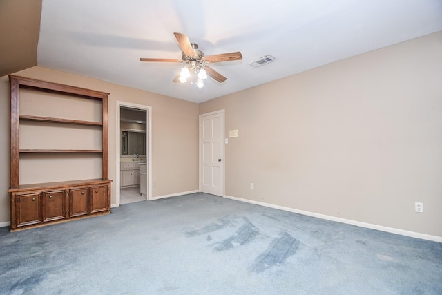 unfurnished bedroom featuring ceiling fan, ensuite bathroom, and carpet floors