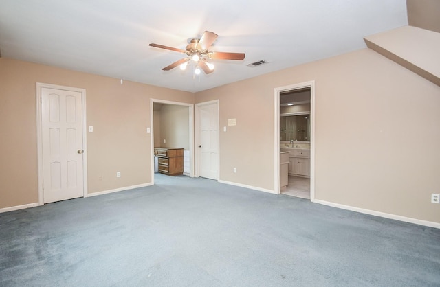 unfurnished bedroom with ensuite bath, ceiling fan, and carpet flooring