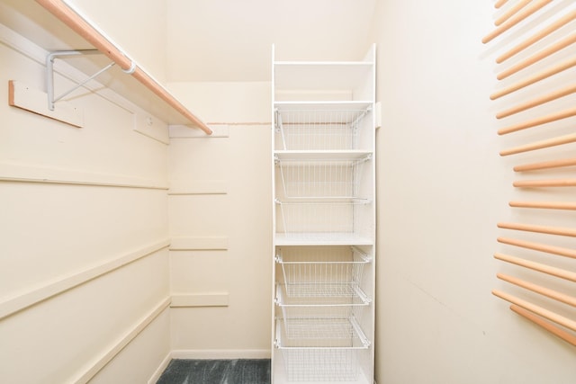 spacious closet featuring dark carpet