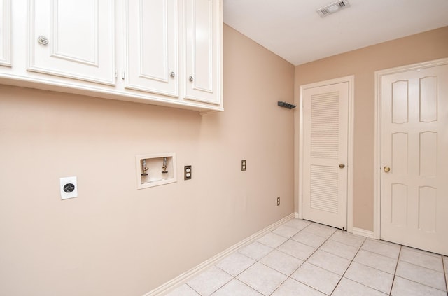 clothes washing area featuring cabinets, electric dryer hookup, washer hookup, and light tile patterned floors