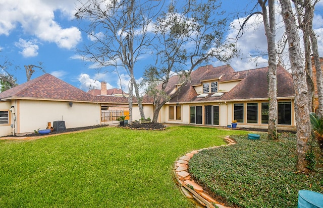 rear view of property with a lawn