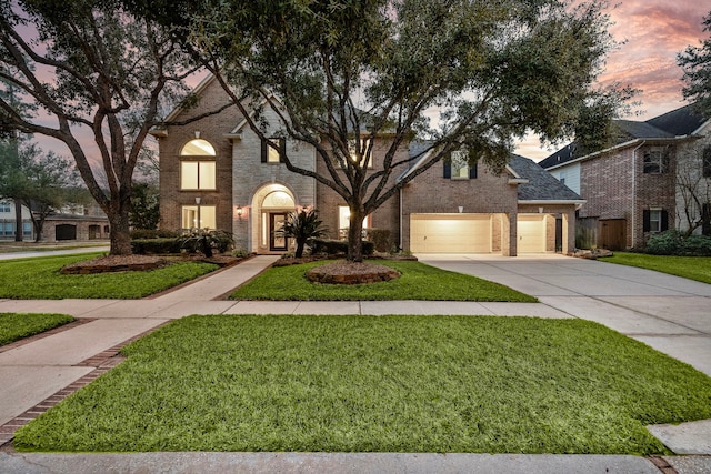 view of front facade featuring a garage, a front yard, concrete driveway, and brick siding