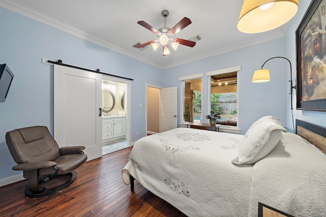 bedroom featuring dark wood-style floors, crown molding, visible vents, a barn door, and baseboards