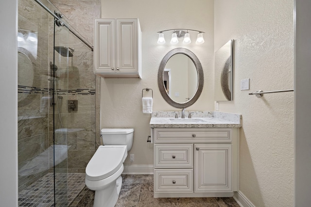 bathroom featuring toilet, a stall shower, baseboards, and vanity