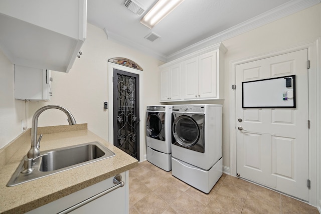 laundry room with a sink, visible vents, ornamental molding, cabinet space, and washer and clothes dryer