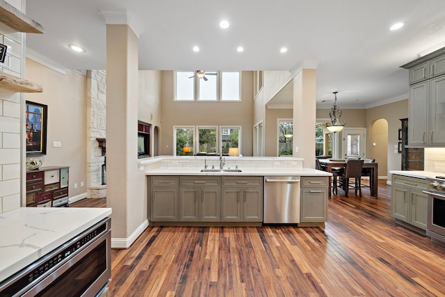 kitchen featuring ornamental molding, stainless steel dishwasher, a sink, and gray cabinetry