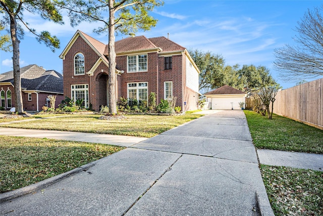 traditional-style house featuring brick siding, fence, a detached garage, and a front lawn