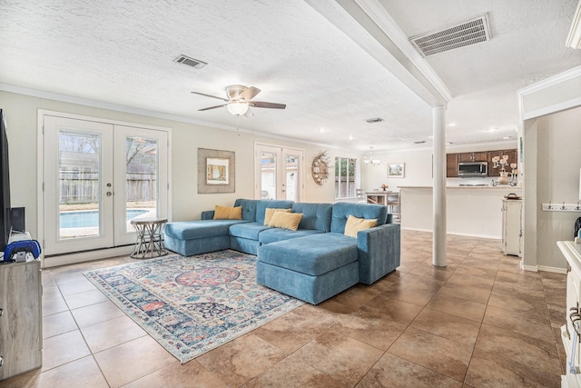 tiled living room with french doors, ornamental molding, and a textured ceiling