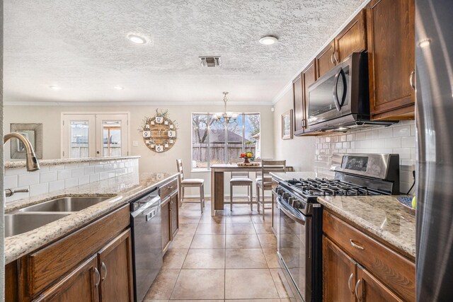 kitchen with sink, decorative backsplash, hanging light fixtures, ornamental molding, and stainless steel appliances