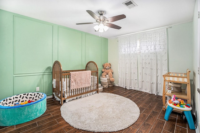 bedroom featuring a nursery area and ceiling fan